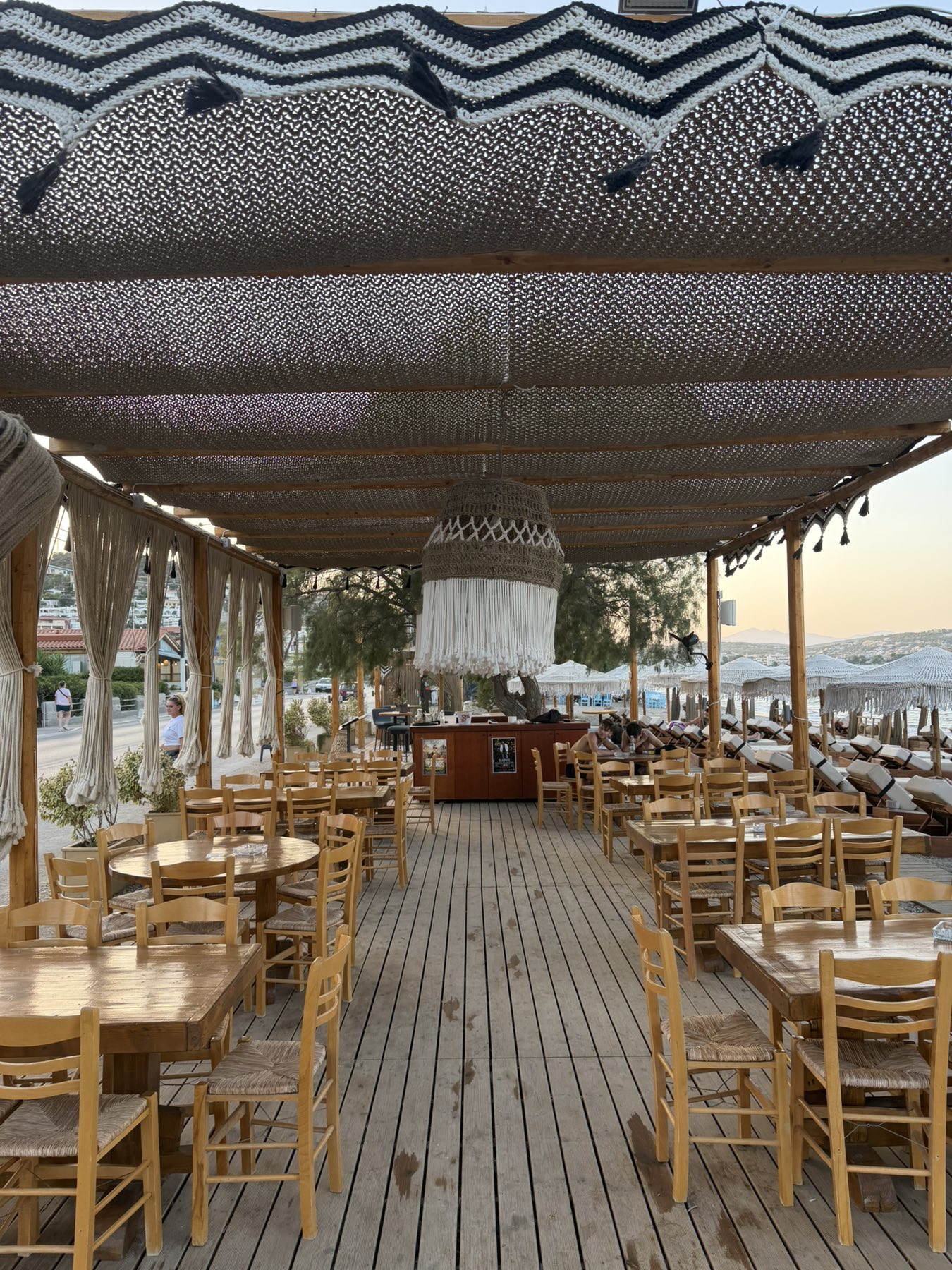 Ο εσωτερικός χώρος του JOJO Porto Rafti με ξύλινο deck και θέα στη θάλασσα